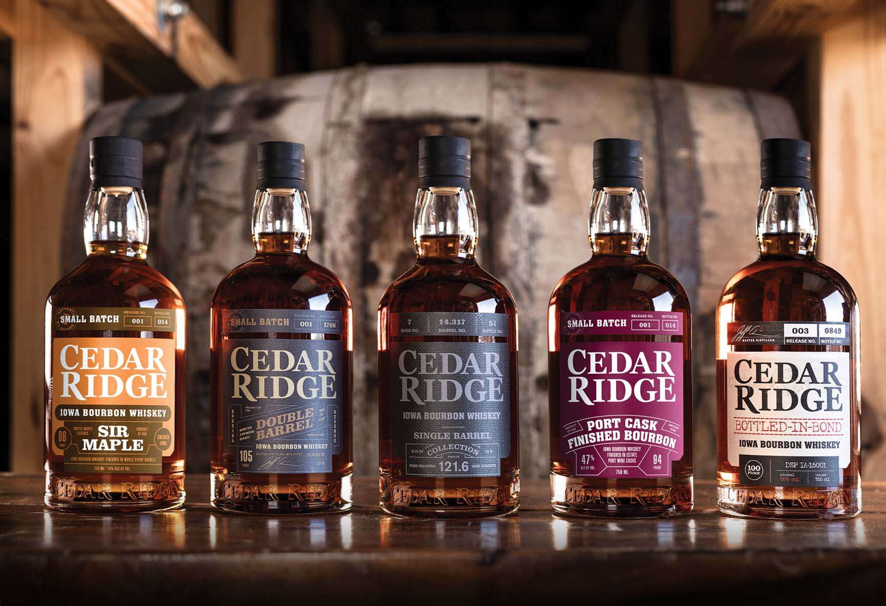 Cedar Ridge Whiskey bottles lined up in front of rick house barrel